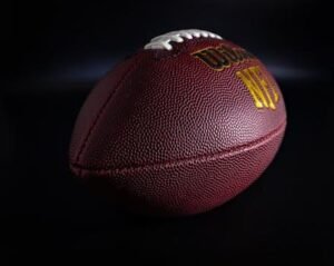 Balón de fútbol americano con iluminación dramática, símbolo de la expansión global de la NFL.