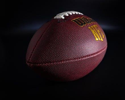Balón de fútbol americano con iluminación dramática, símbolo de la expansión global de la NFL.